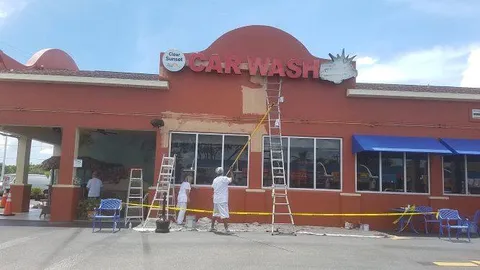 Close-up of commercial exterior painting in progress at a car wash in Venice, FL